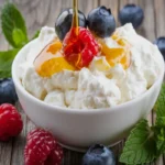 A close-up image of fresh cottage cheese served in a white bowl, highlighting its creamy texture.